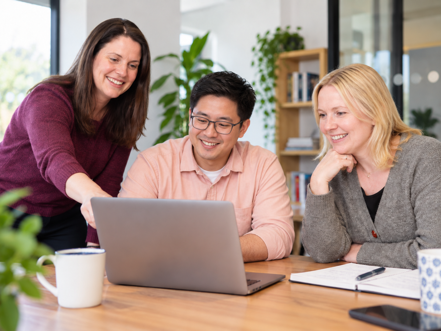 Team collaborating around a laptop