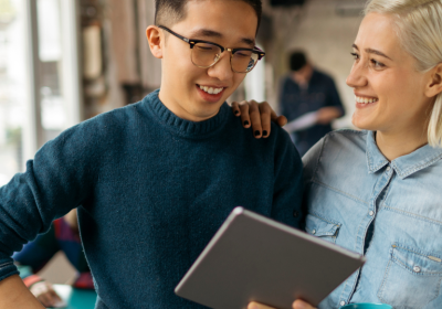 Two young creative professionals discuss something while looking at an iPad